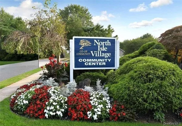 a view of a sign board with yard and outdoor seating