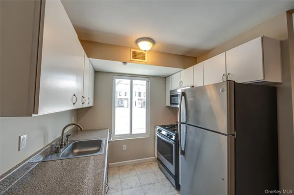 a kitchen with a refrigerator a sink and cabinets