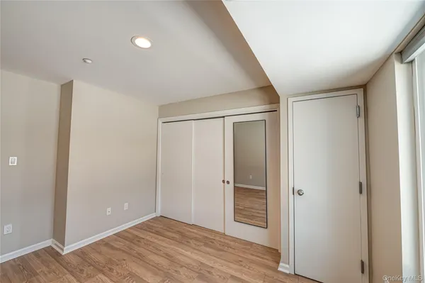an empty room with wooden floor and closet