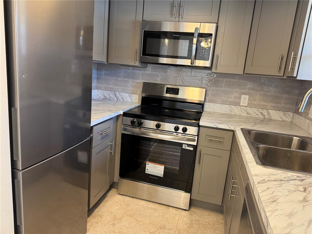 5154 Turquoise Lane, Unit 102 New Port Richey, FL 34652 - Photo 5 of 11 a kitchen with a stove and a microwave