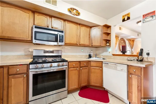 a kitchen with stainless steel appliances granite countertop a stove microwave and sink