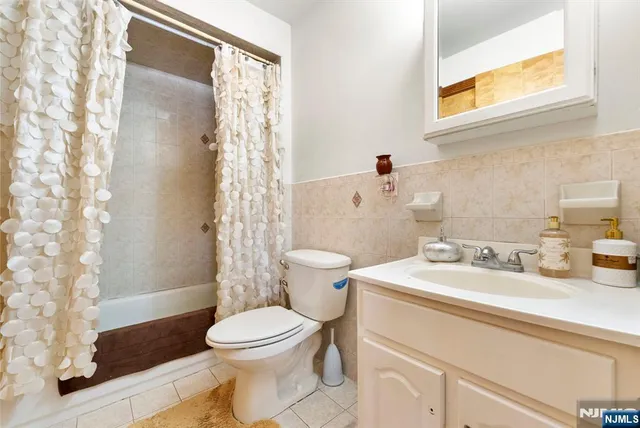 a bathroom with a sink a toilet and shower curtain