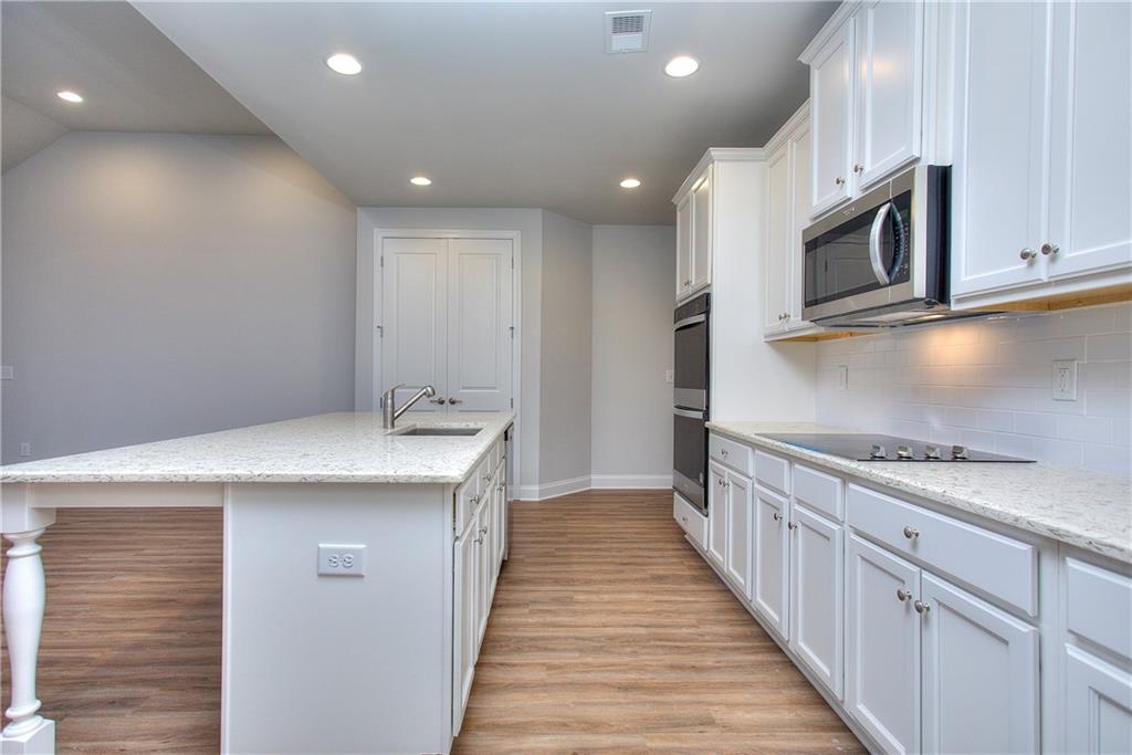 2604 Parkside Way Gainesville, GA 30507 - Photo 23 of 35 a kitchen with stainless steel appliances granite countertop a sink and a stove top oven