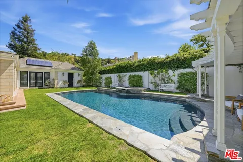 a view of swimming pool with a couches in a patio