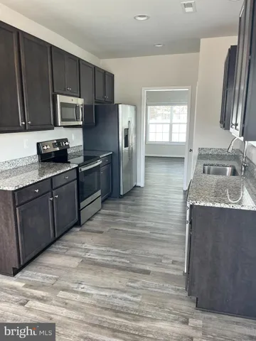 a kitchen with stainless steel appliances granite countertop a sink a stove and a microwave oven