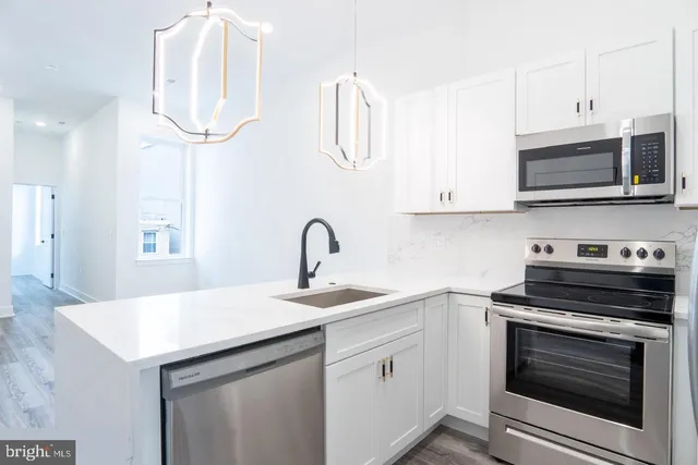 a kitchen with stainless steel appliances granite countertop a sink and cabinets