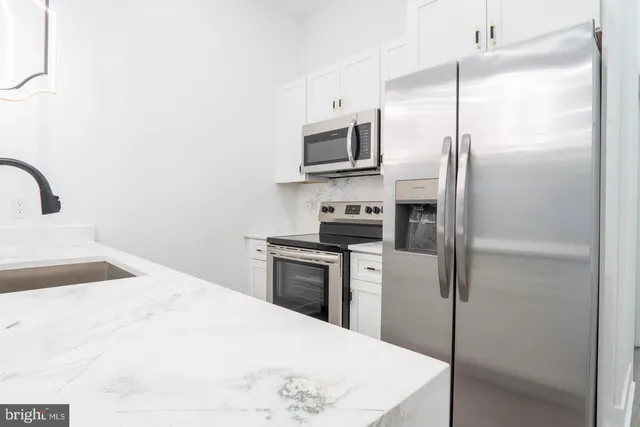 a kitchen with stainless steel appliances a refrigerator sink and microwave