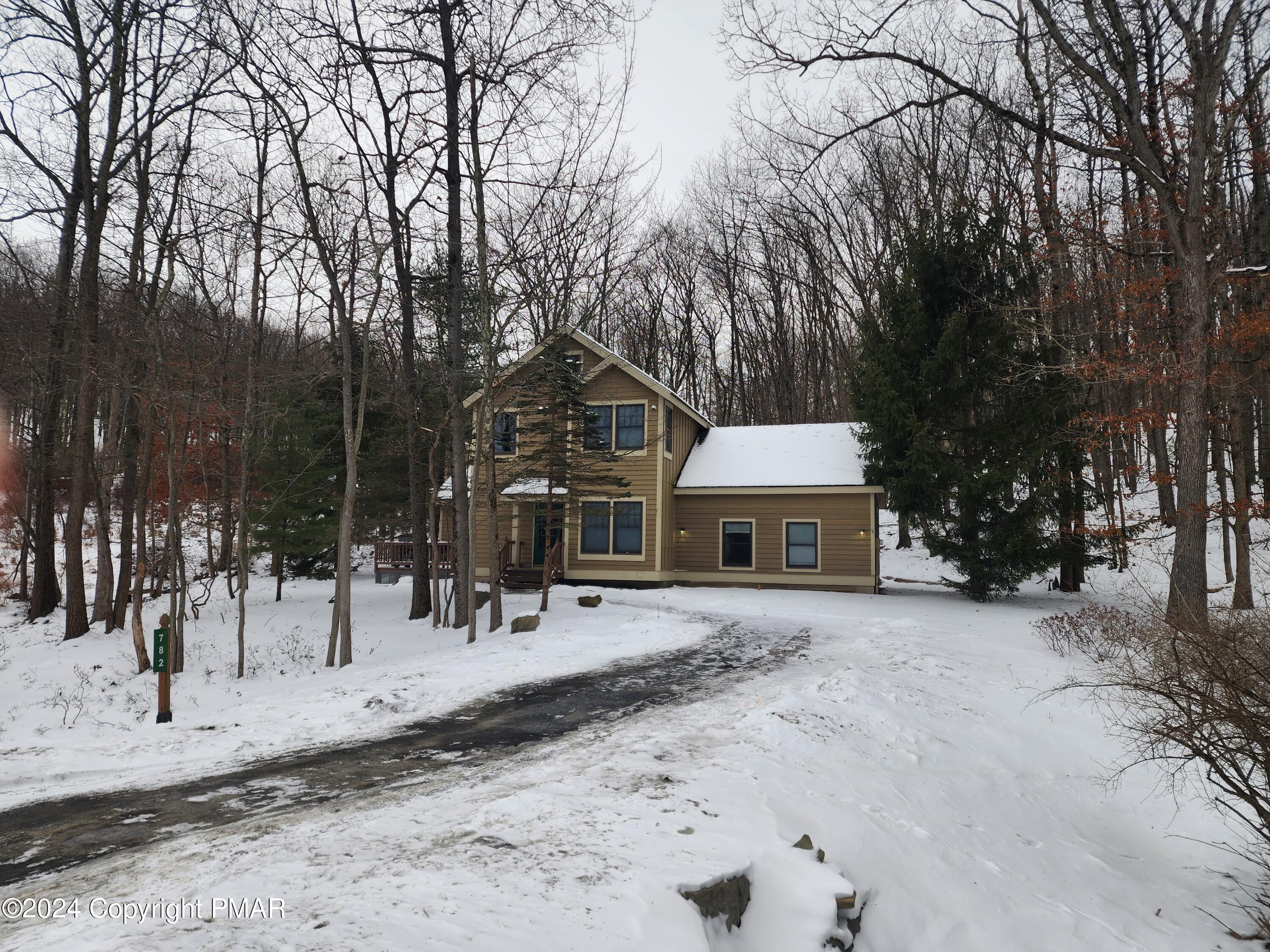 a view of a house with snow on the road