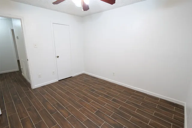 a view of a room with wooden floor and white walls