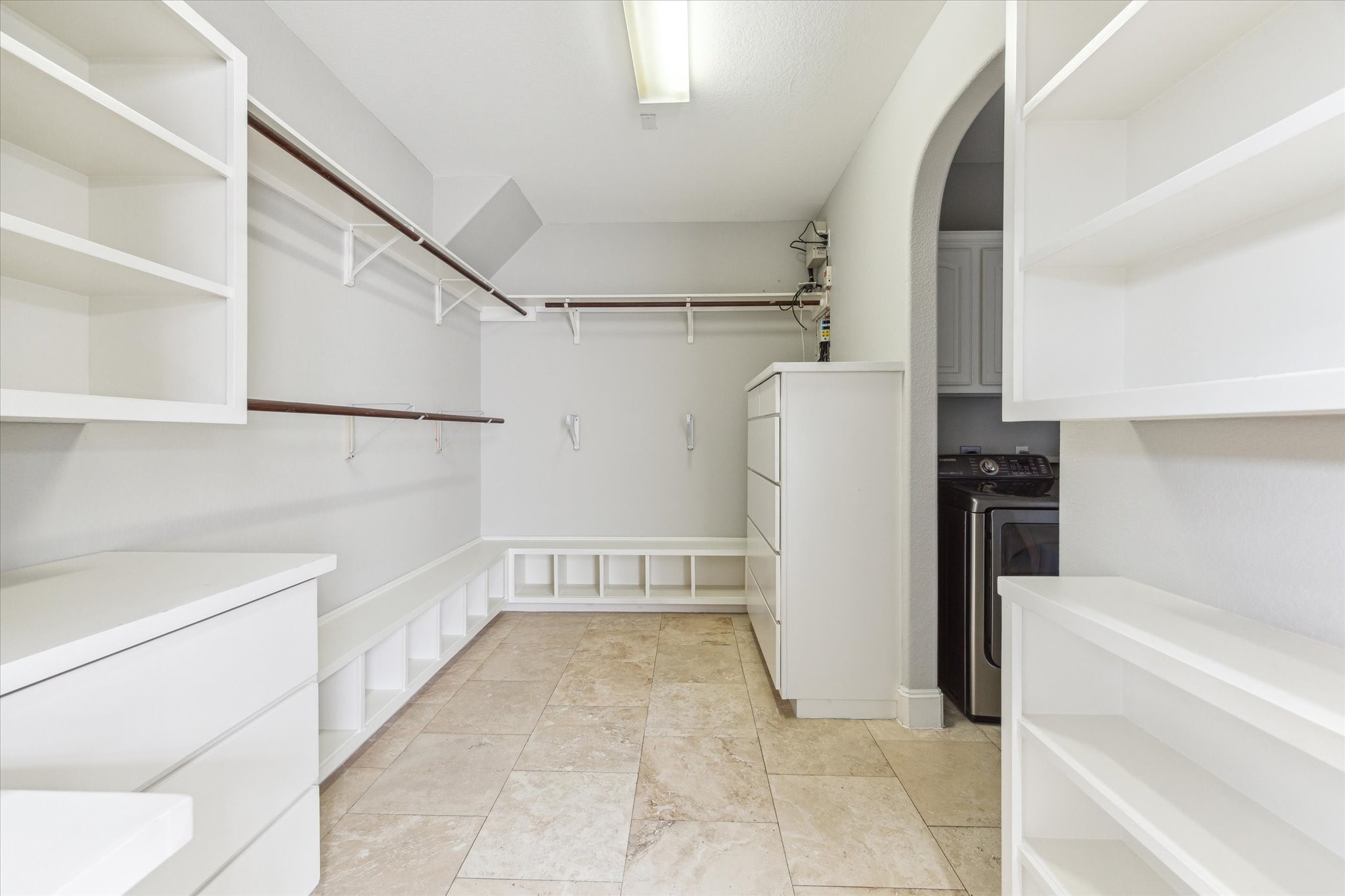 1512 Thompson Street, Unit 3 Houston, TX 77007 - Photo 22 of 32 Spacious walk-in closet with ample shelving, hanging rods, and built-in storage. It features tile flooring and an open archway leading to an adjacent laundry area.