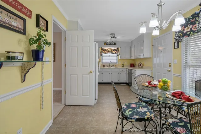 a kitchen that has a lot of cabinets a sink and a dining table