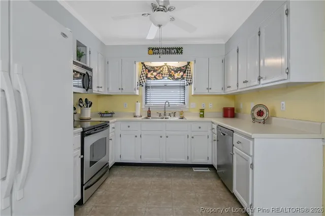 a kitchen with granite countertop a sink window and cabinets