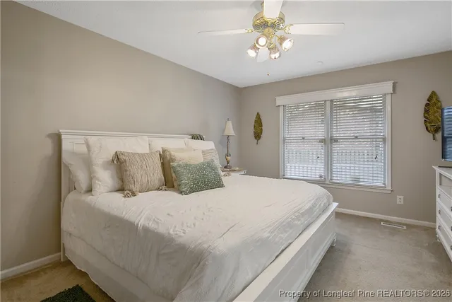 a large bed sitting in a bedroom next to a window and a chandelier