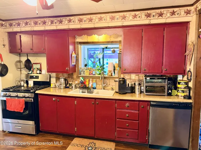 a kitchen with stainless steel appliances granite countertop a sink stove and cabinets