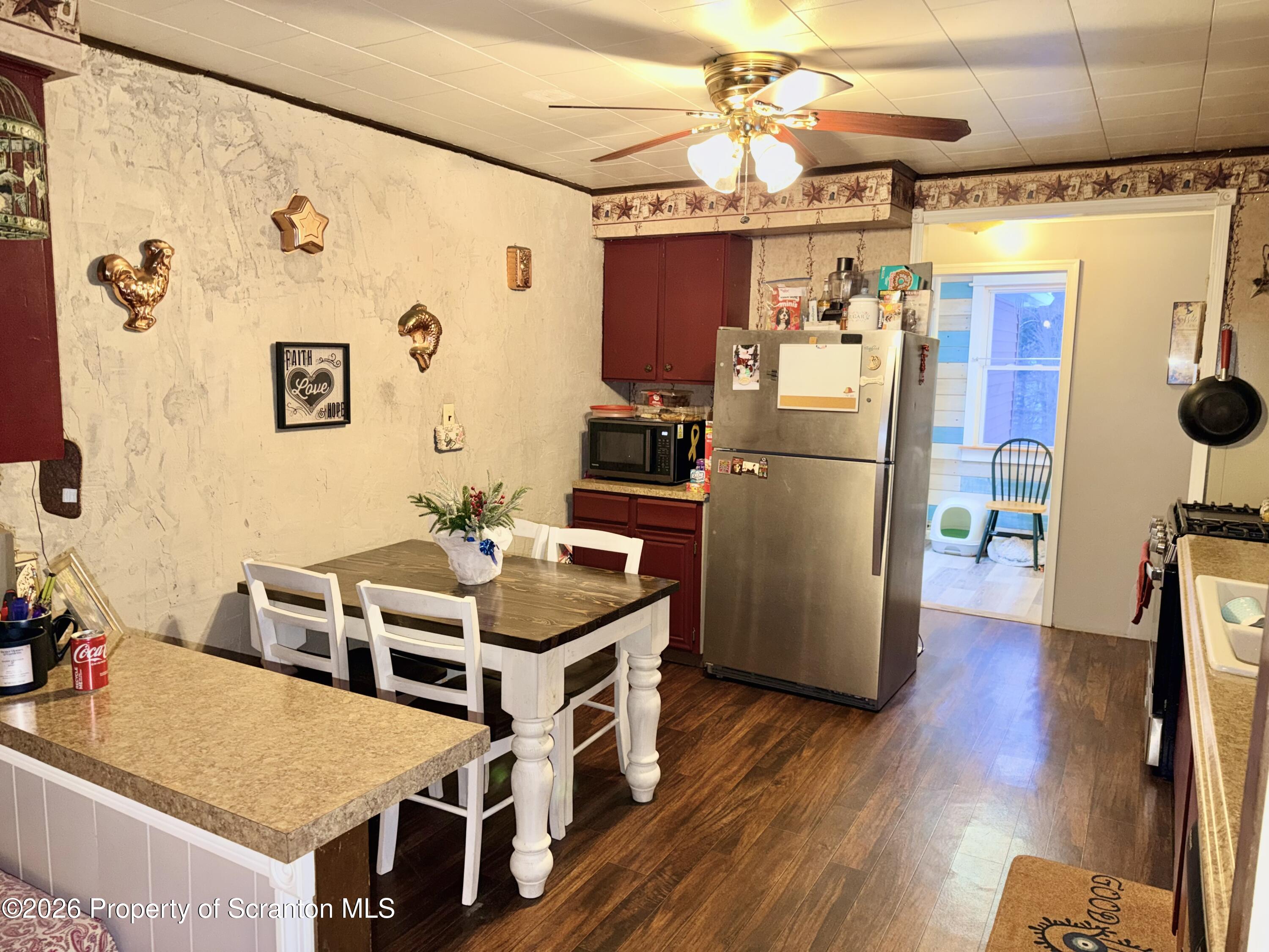 338 Bailey Street Clarks Summit, PA 18411 - Photo 12 of 24 a kitchen with stainless steel appliances a stove a refrigerator and a dining table with wooden floor