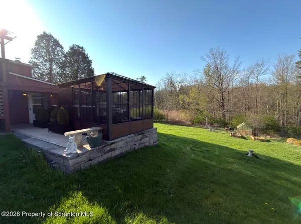a view of a backyard with a garden and entertaining space