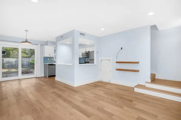 a view of a kitchen with wooden floor and a refrigerator
