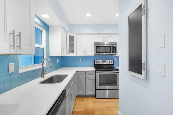 a kitchen with a sink and stainless steel appliances