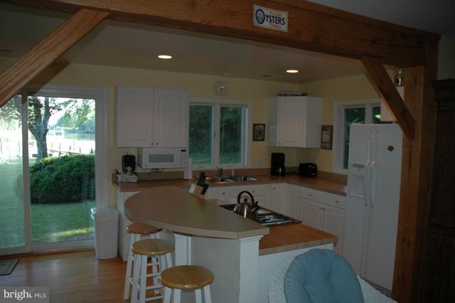 24611 Long Haul Road St. Michaels, MD 21663 - Photo 6 of 16 a kitchen with a sink a counter top space and living room filled with furniture