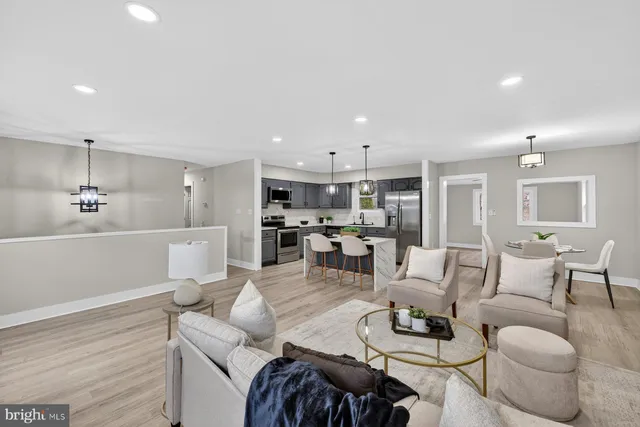 a living room with furniture kitchen view and a chandelier