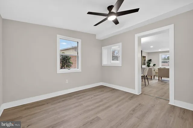 a view of a room with wooden floor and a ceiling fan