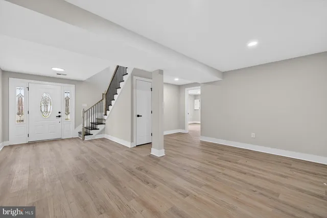 an empty room with wooden floor and white walls