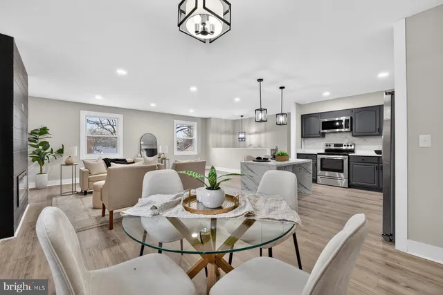 a living room with furniture kitchen view and a wooden floor