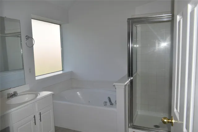 a bathroom with a bathtub a shower and a sink