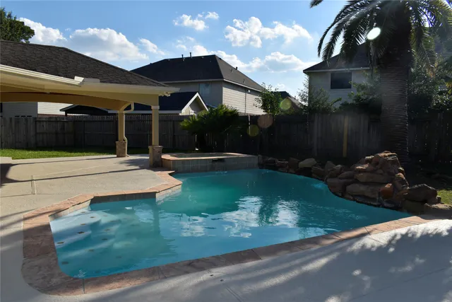 a swimming pool with outdoor seating and yard