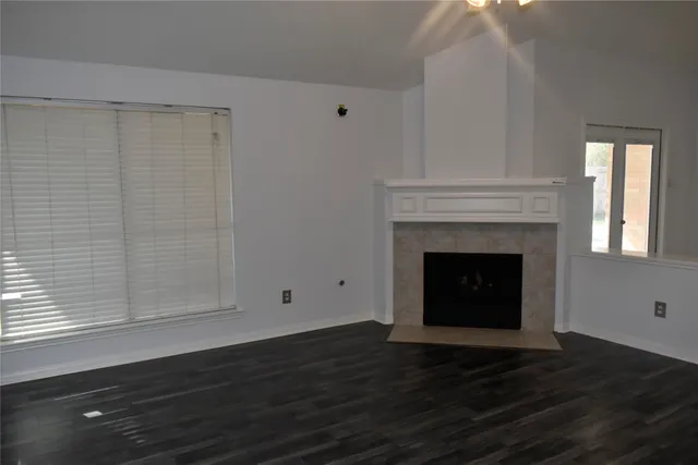 a view of a livingroom with wooden floor and a fireplace