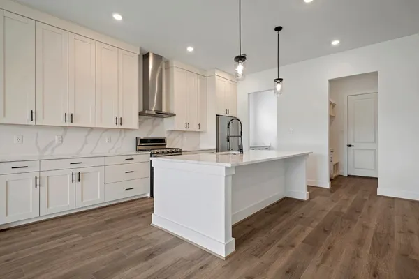 a kitchen with kitchen island a counter top space wooden floor and a ceiling fan