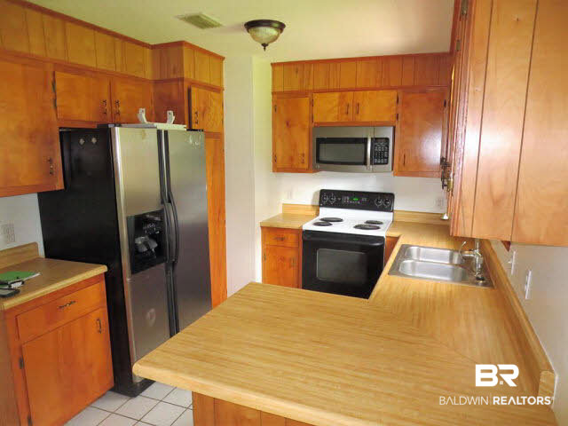 204 West Sycamore Avenue Foley, AL 36535 - Photo 2 of 11 Kitchen with tons of cabinet space, a nice side by side refrigerator and a nice counter!