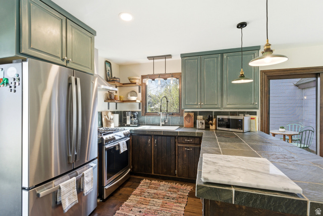 2635 Little Kate Road, Unit 21 Park City, UT 84060 - Photo 11 of 39 Kitchen with stainless steel appliances, pendant lighting, green cabinets, dark wood finished floors, and a peninsula