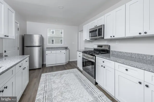 a kitchen with granite countertop a sink stove and refrigerator