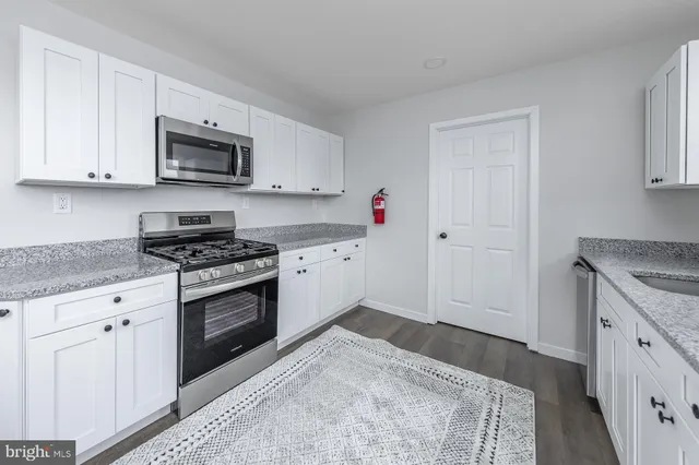a kitchen with granite countertop a sink and a stove top oven