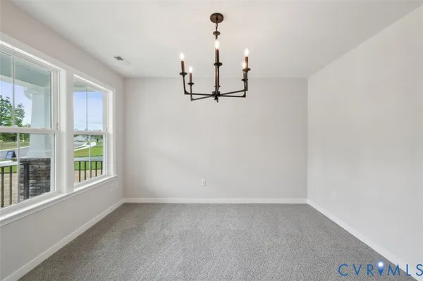 a view of an empty room with wooden floor fireplace and a window