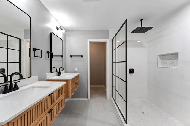 a bathroom with double vanity and mirrors