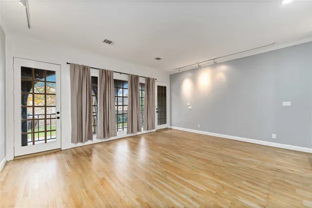a view of an empty room with glass door and a window