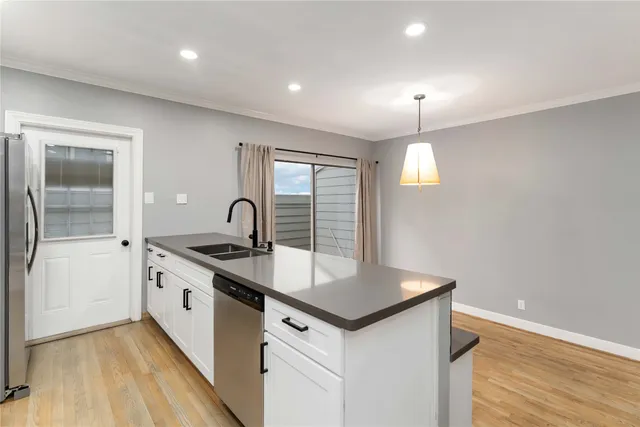 a kitchen with granite countertop a sink and wooden floor