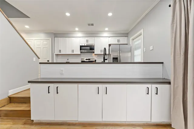 a kitchen with stainless steel appliances kitchen island sink refrigerator and microwave