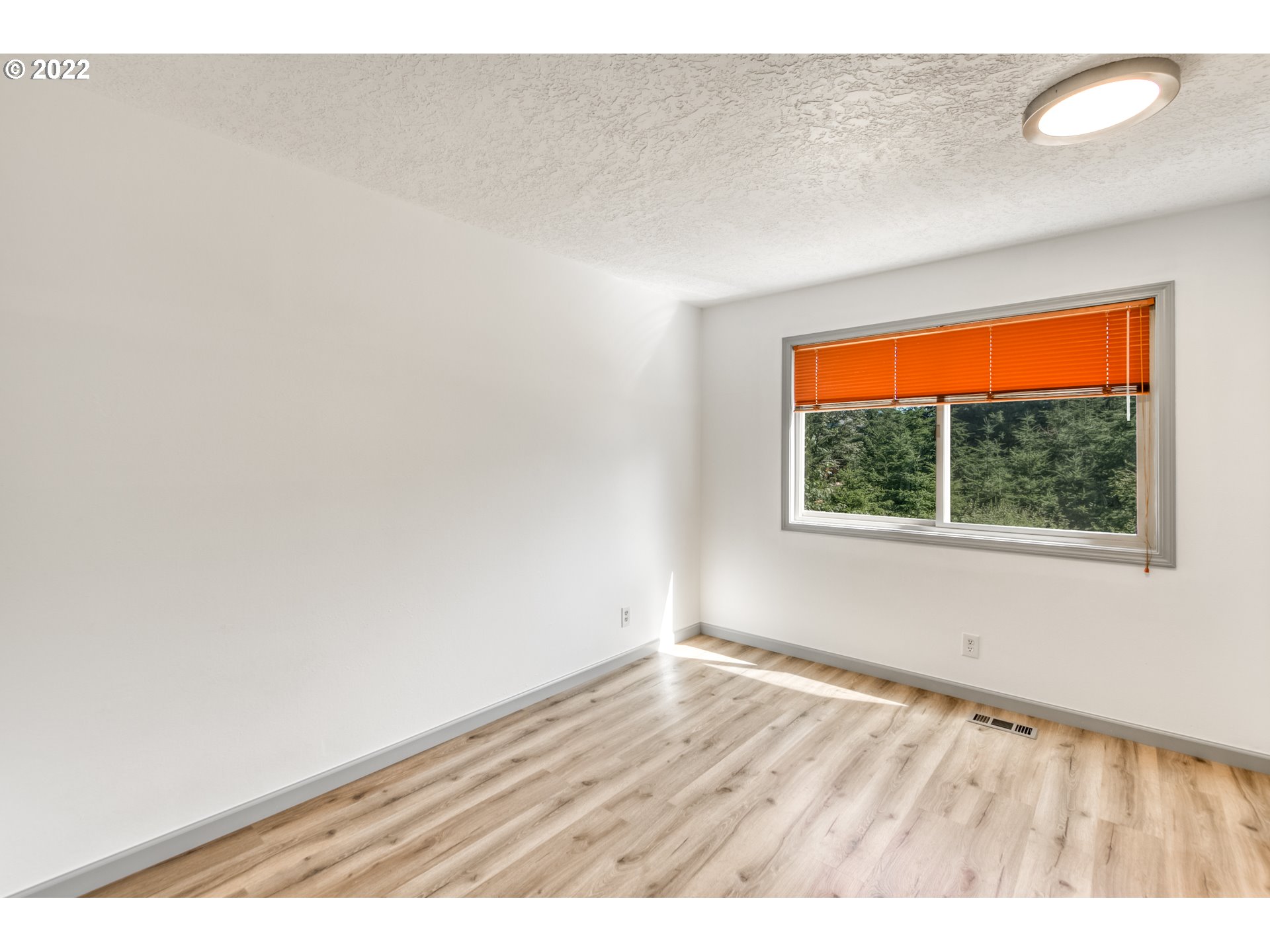 4435 Southeast Regner Road Gresham, OR 97080 - Photo 23 of 32 an empty room with wooden floor and windows