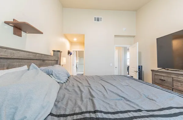 a bedroom with a bed and a flat screen tv