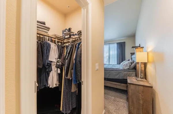 a view of walk in closet with clothes and shoes