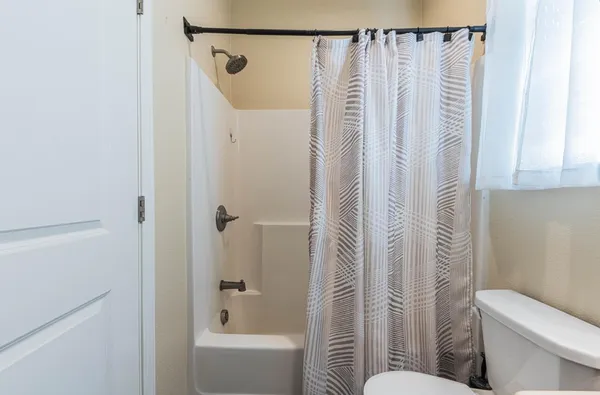 a bathroom with a shower curtain and a toilet