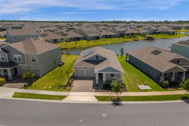 an aerial view of residential houses with outdoor space and ocean view