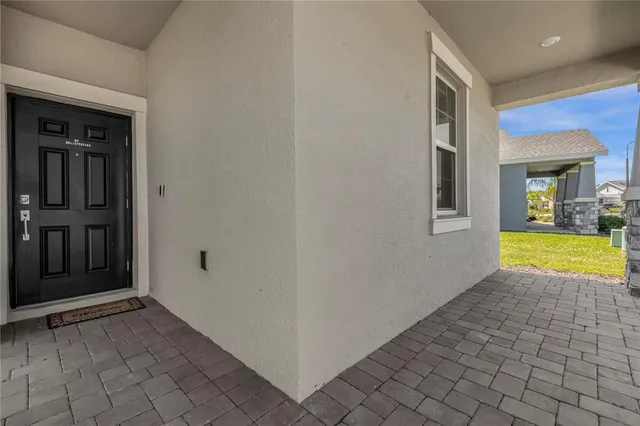 a view of an empty room with window and a kitchen