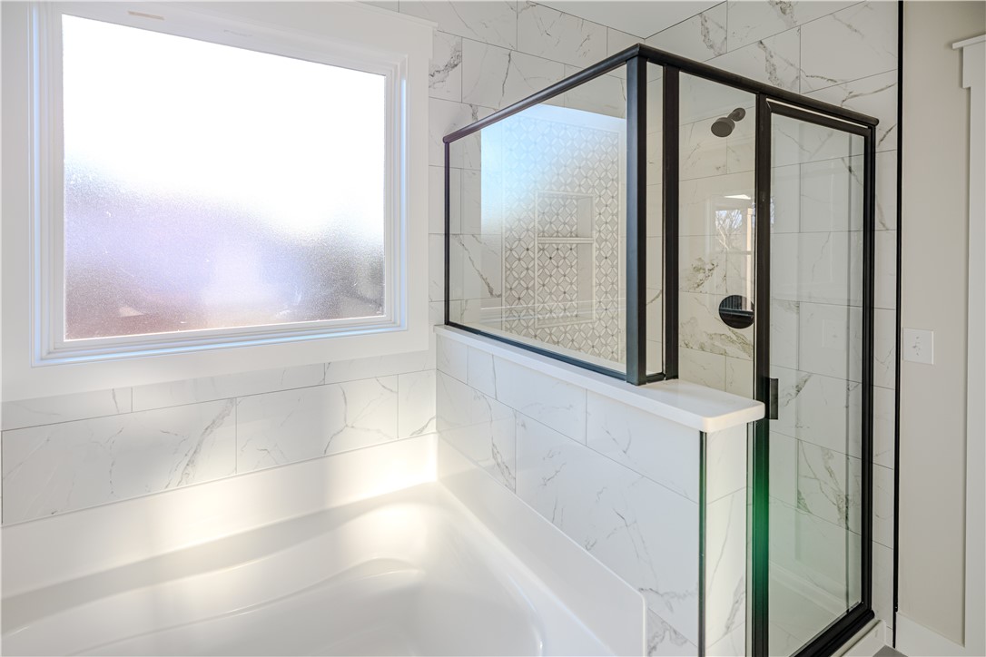 1409 Stonehurst Road Anderson, SC 29621 - Photo 25 of 37 This bathroom features a sleek glass-enclosed shower alongside a pristine bathtub, offering a serene retreat.