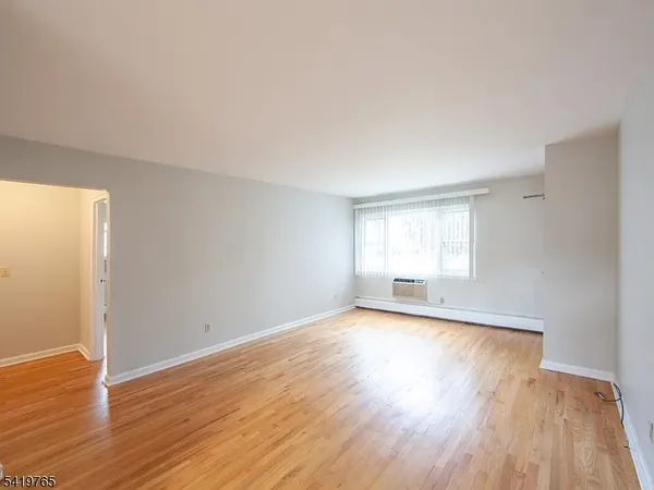 a view of a room with wooden floor and window