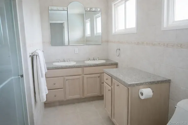 a bathroom with a granite countertop sink toilet a mirror and shower