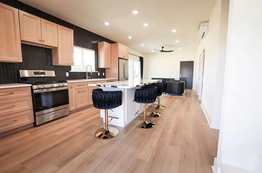 6724 Clearwater Ranch Road Wills Point, TX 75169 - Photo 27 of 38 a kitchen with stainless steel appliances granite countertop a stove a sink dishwasher a refrigerator white cabinets with wooden floor